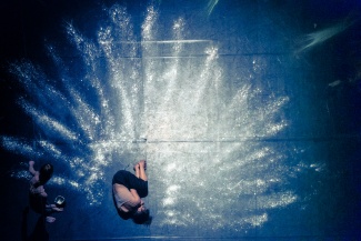 artist laying on stage in a circle of white dust